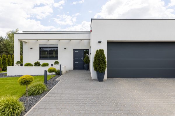 Outside view of elegant suburban house with big window green lawn